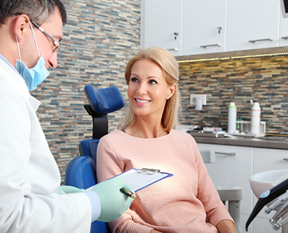 Woman in dental chair listening to her dentist