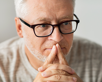 Senior man with glasses looking pensive