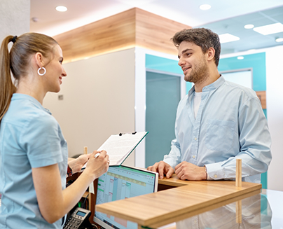 Man checking in at front desk of dental office