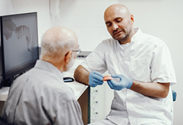 Dentist showing a model of a denture to a patient