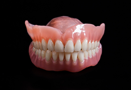 Full dentures against a black background