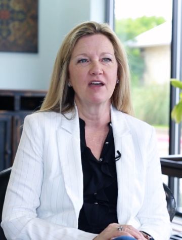 Woman in a white blazer sitting in dental office