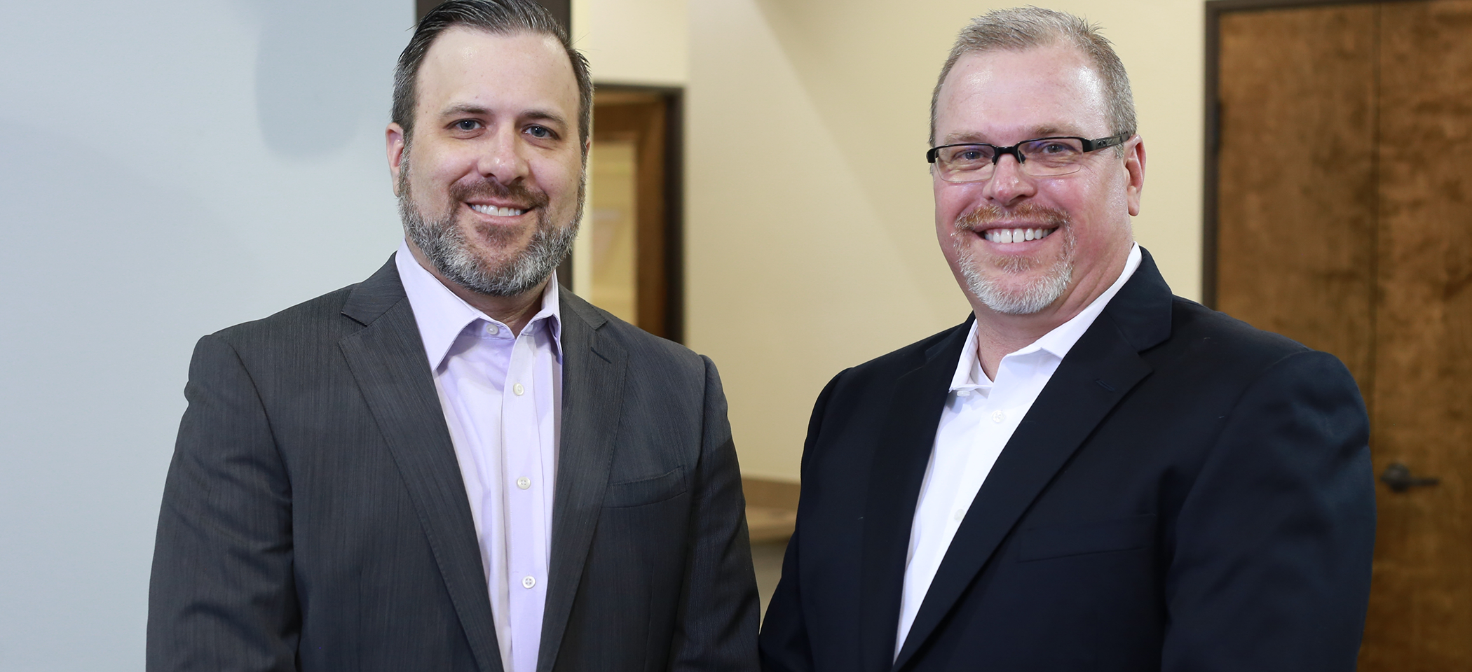 Doctor Robert Long and Doctor Chris Long smiling in dental office in Cleburne