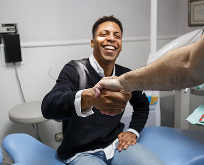 Smiling man shaking hands with his dentist