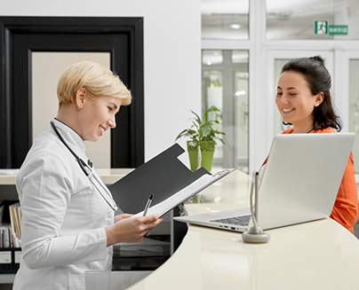 WOman checking in at front desk in dental office