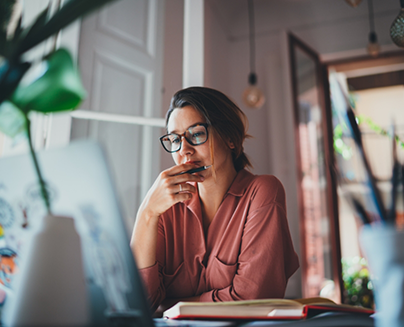 Woman looking pensive while looking at her laptop