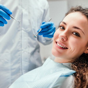 patient smiling while sitting in dental chair