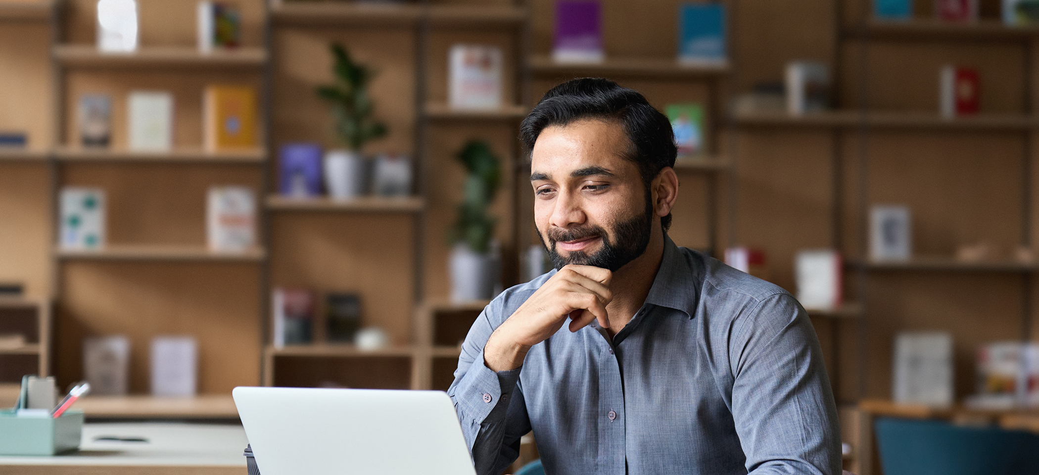 Man smiling while looking t his laptop