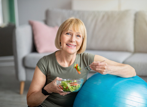 woman eating salad with dentures
