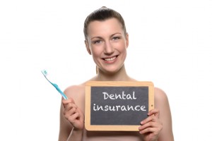 Woman smiling with dental insurance sign needs to visit her dentist in midlothian